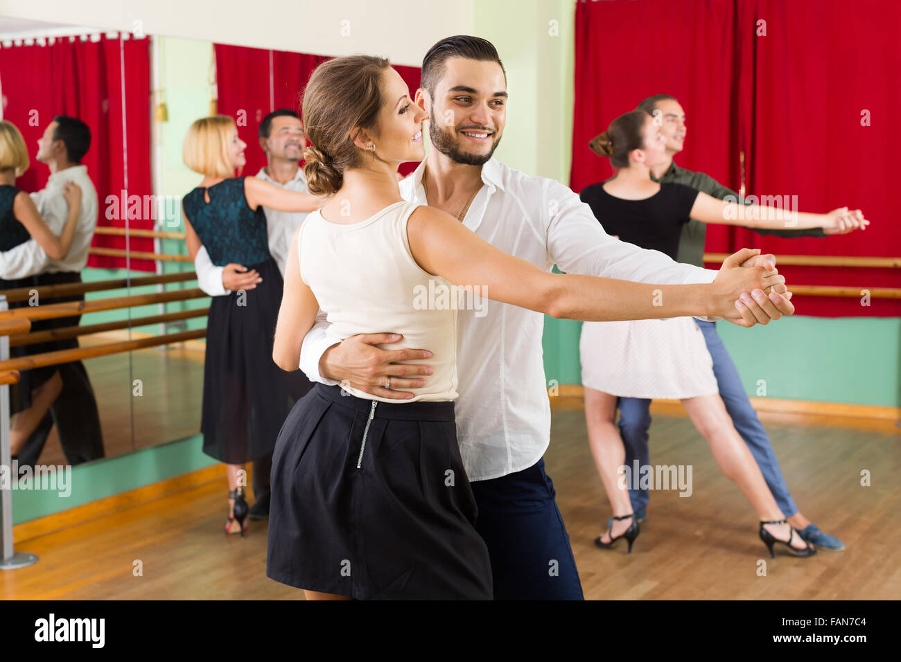 positive spanish men and women enjoying of tango in class Stock Photo ...