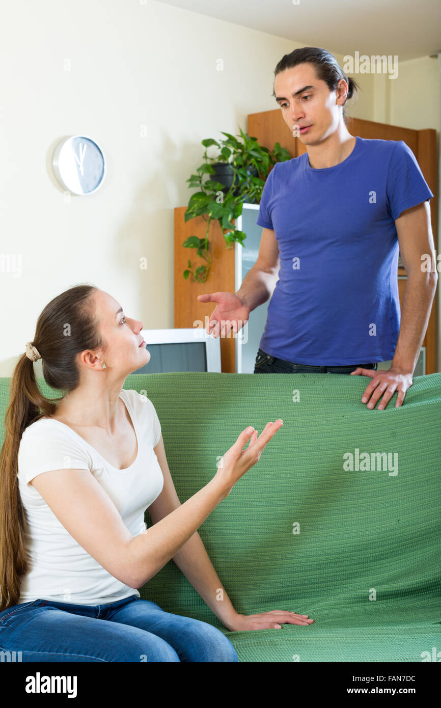 Young couple having serious talking in home interior. Focus on woman ...