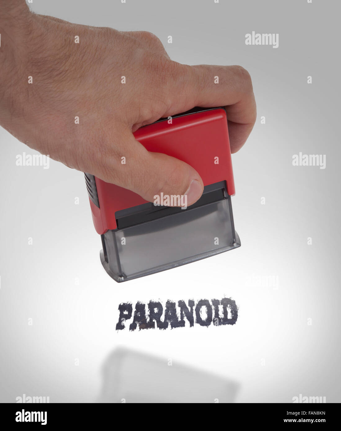 Plastic stamp in hand, isolated on white - Paranoid Stock Photo