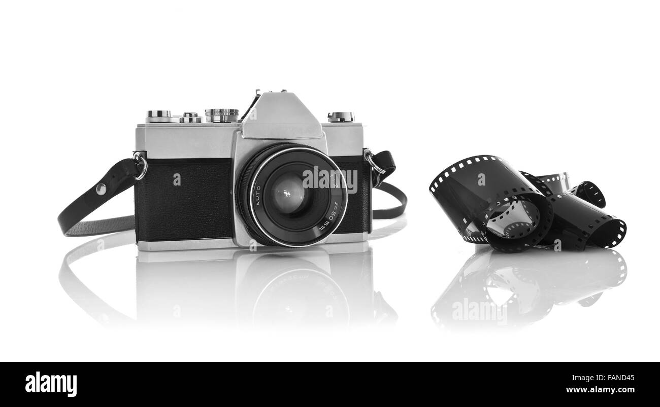 Old 35mm film photo camera on white background with 35mm film strip Stock Photo