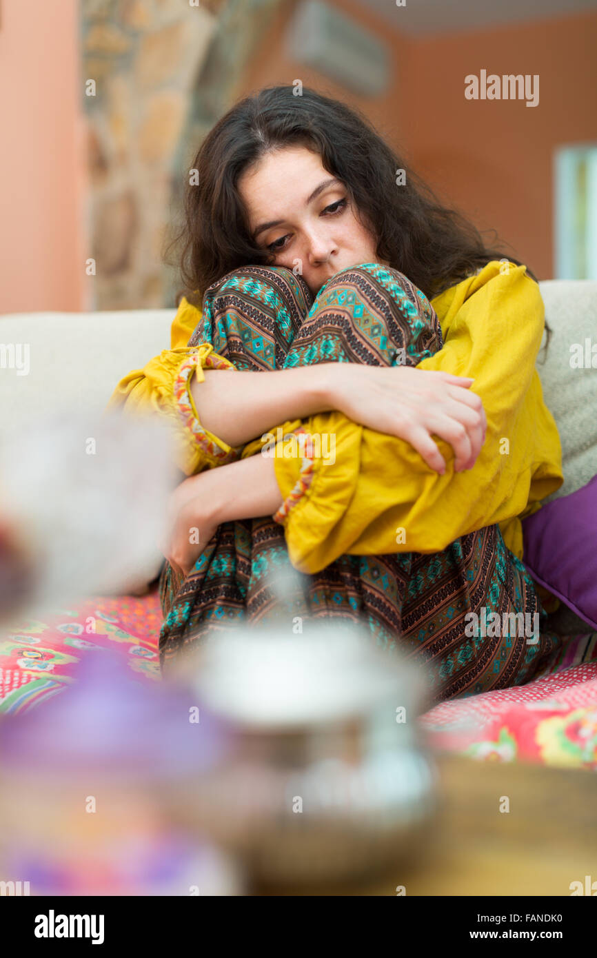 Sad and lonely woman sitting on couch at home Stock Photo - Alamy
