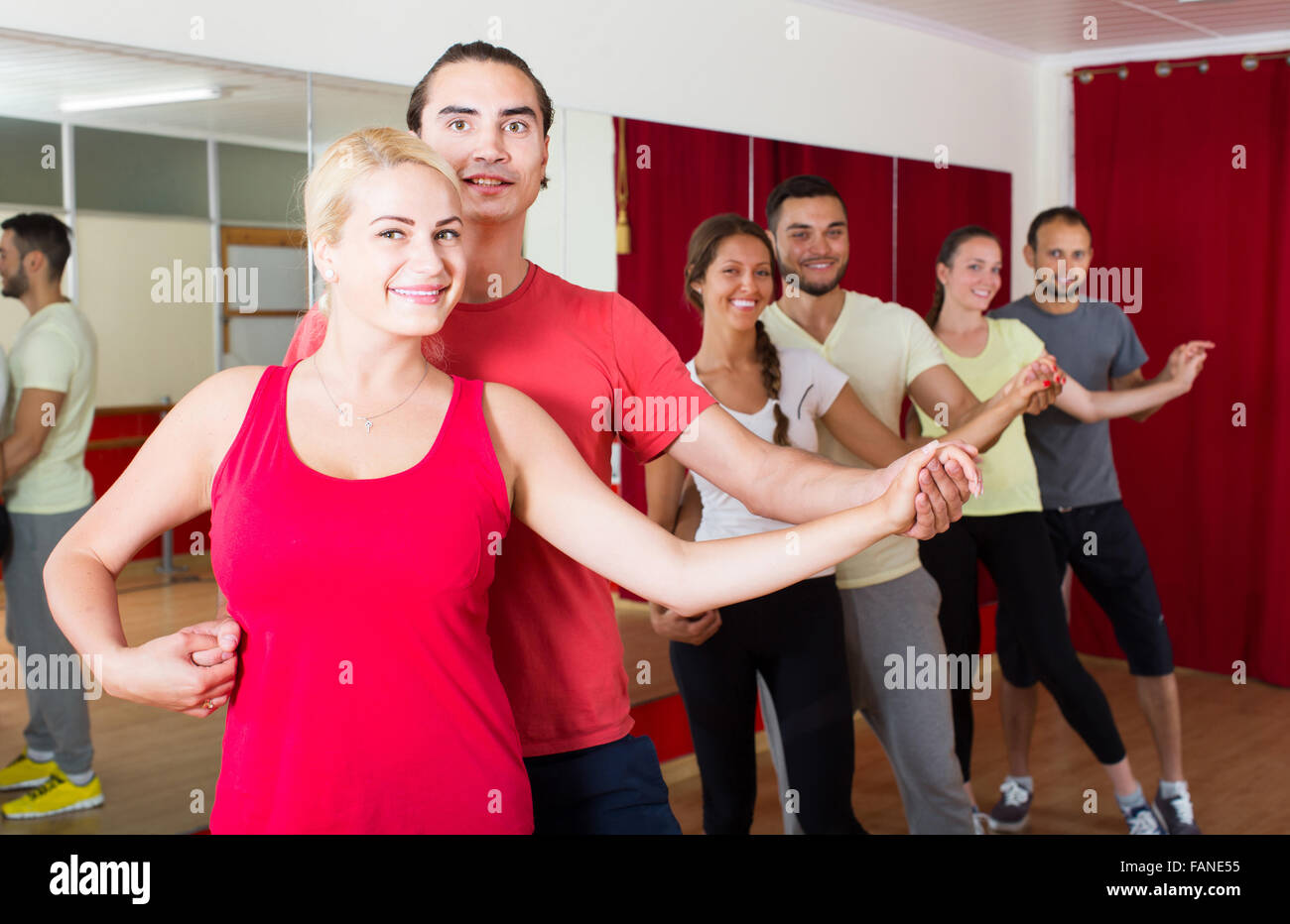 Group of happy spanish people dancing salsa in studio Stock Photo