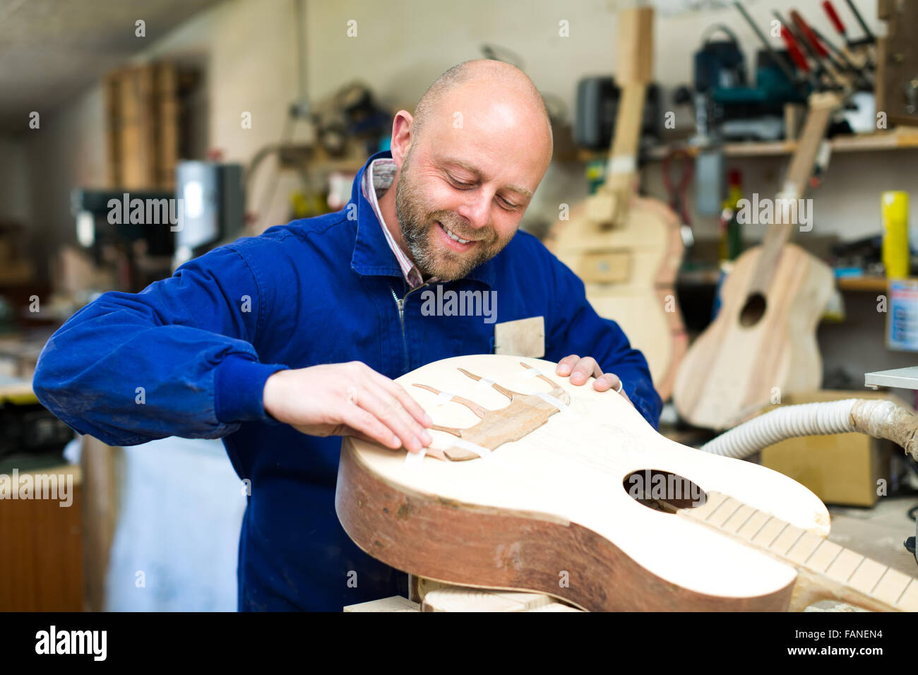 Professional guitar maker in a process of making a custom acoustic