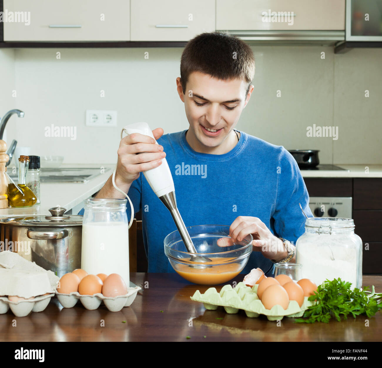 Guy cooking scrambled eggs for breakfast in the kitchen Stock Photo Alamy
