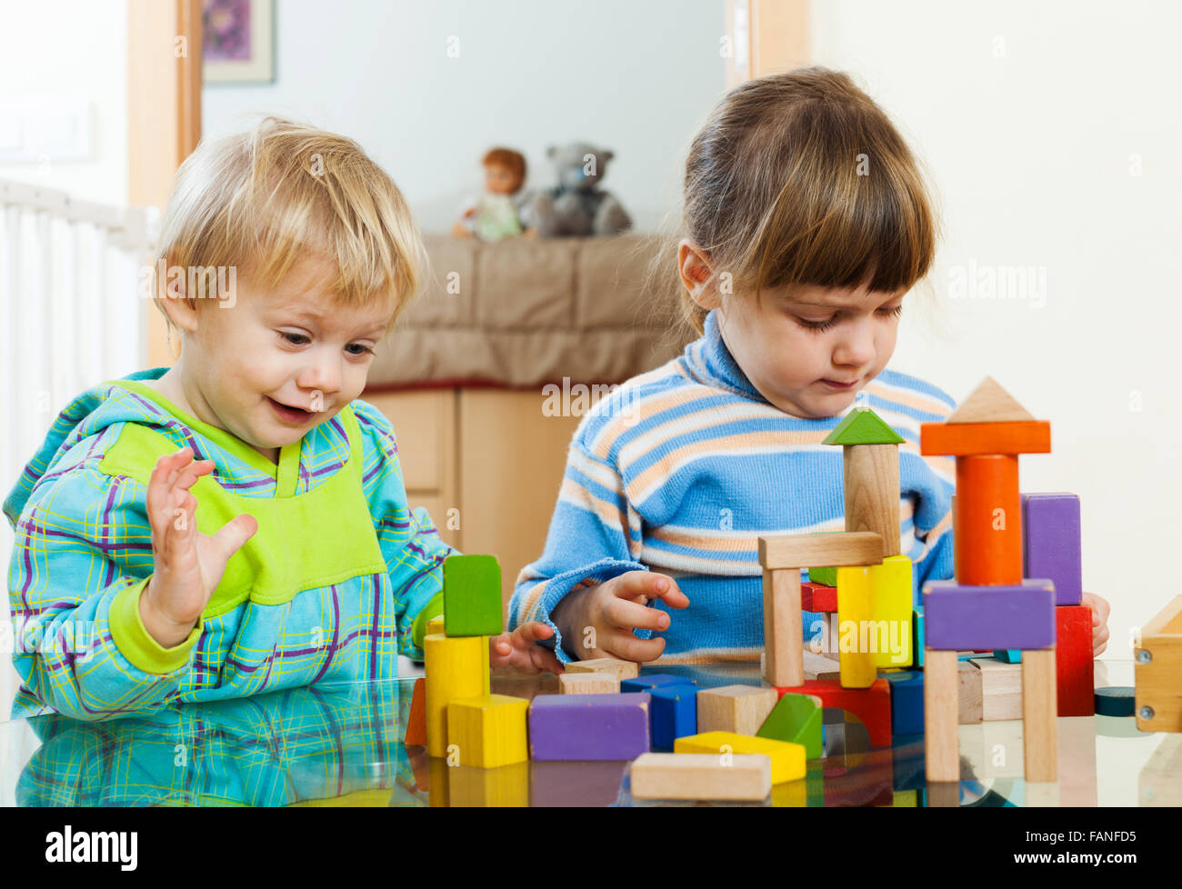 Two children playing with wooden blocks in home Stock Photo - Alamy