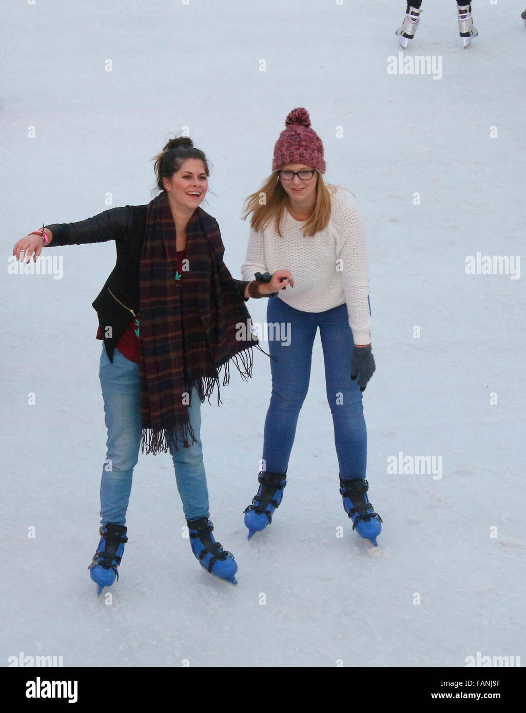 Two Dutch girls skating at the temporary skating rink on Museumplein (Museum Square), Amsterdam, Netherlands Stock Photo