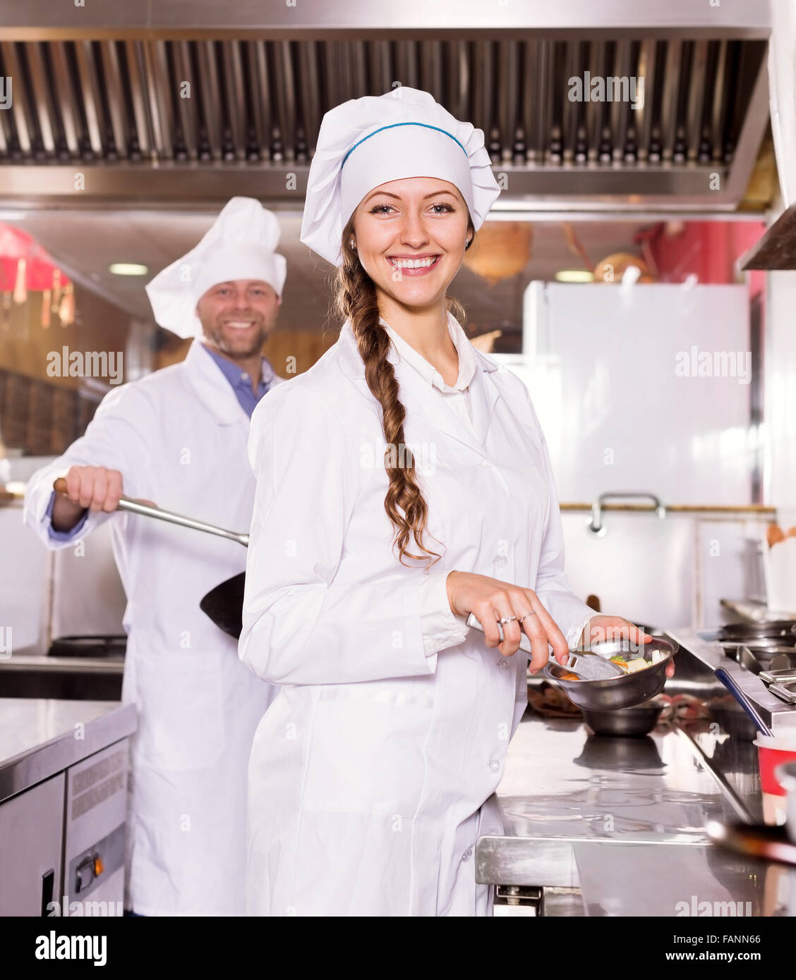portrait young woman cook cooking at professional kitchen in the take-away  restaurant Stock Photo