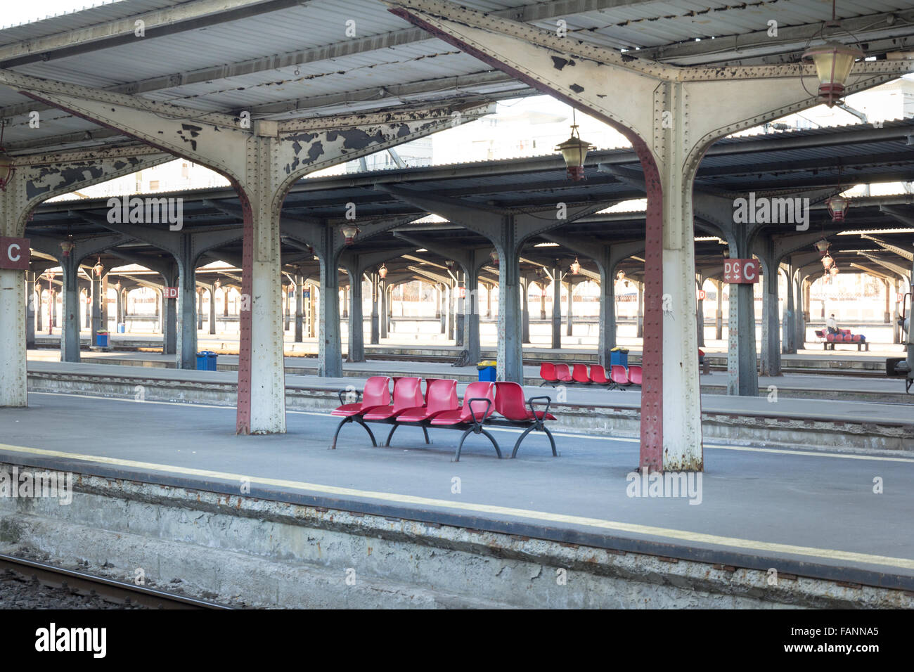Red chairs in a romanian train station with symmetric pillars Stock Photo