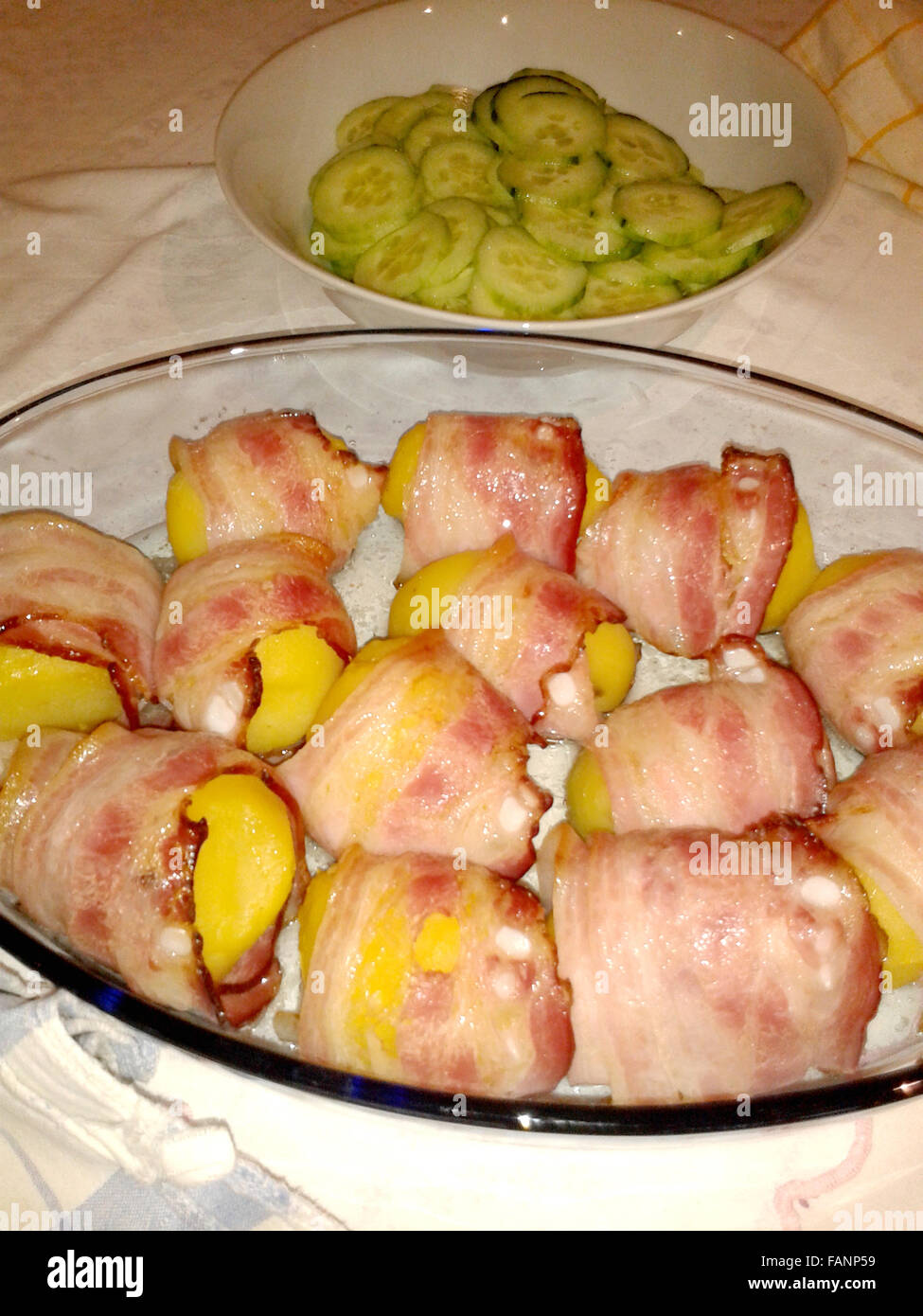 boiled potatoes wrapped in bacon ready to cook Stock Photo