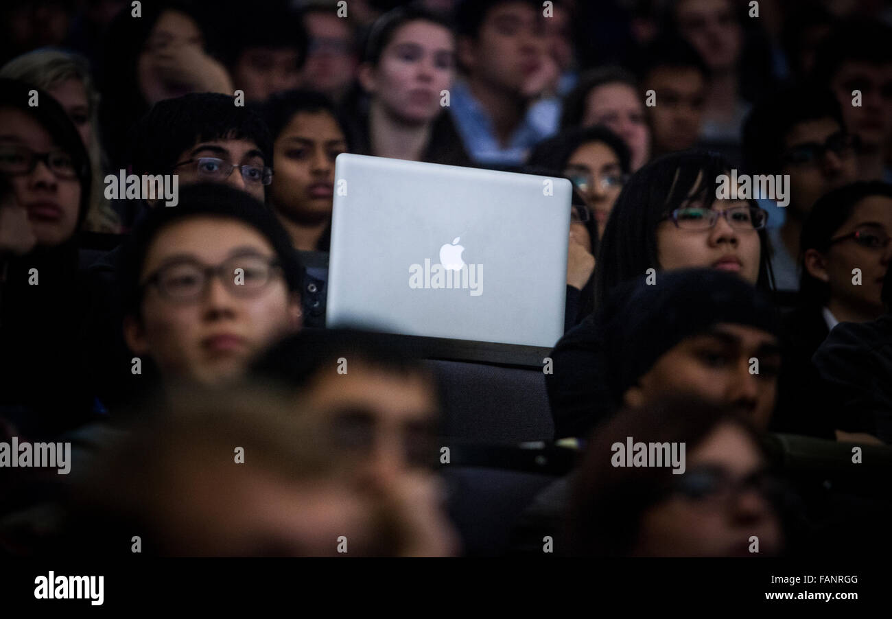 A student using an Apple laptop computer during a seminar at a University lecture. Stock Photo