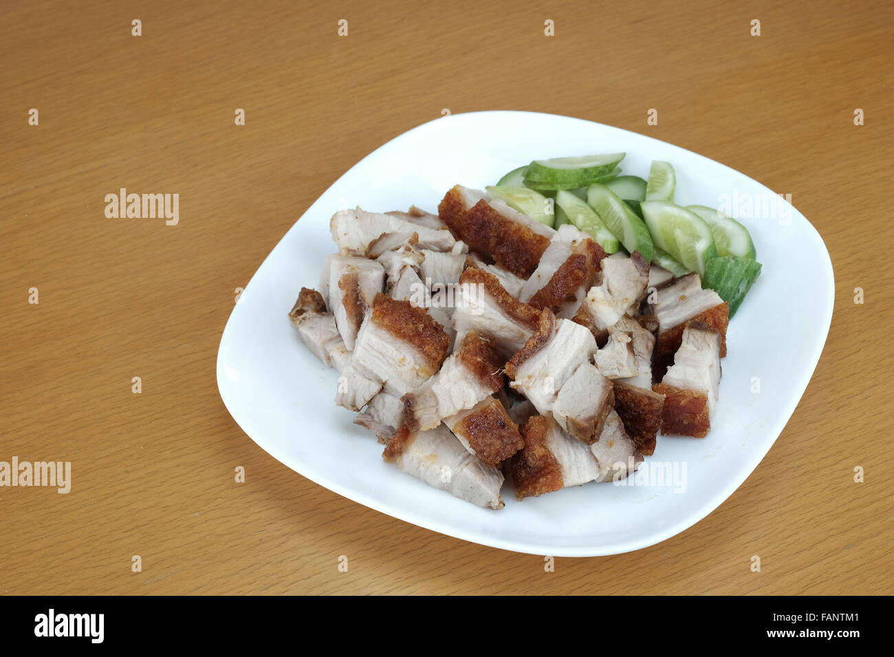 Dish of crispy pork on wood table Stock Photo