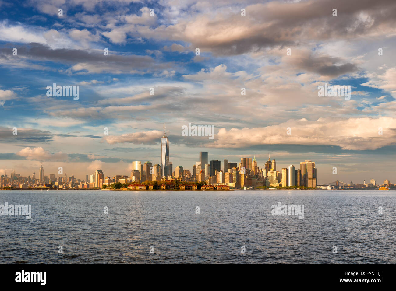 Lower Manhattan Financial District Skyscrapers, One World Trade Center and Ellis Island in late afternoon from New York Harbor Stock Photo