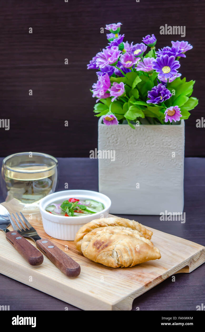 Curry puff pastry with sweet sauce  on wooden plate Stock Photo