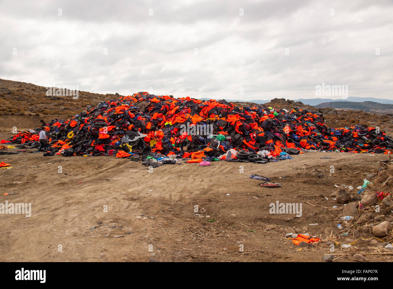 cleaning up discarded  life jackets after the arrival of refugees asylum seekers and immigrants on the island of Lesbos Greece by inflatable boats Stock Photo