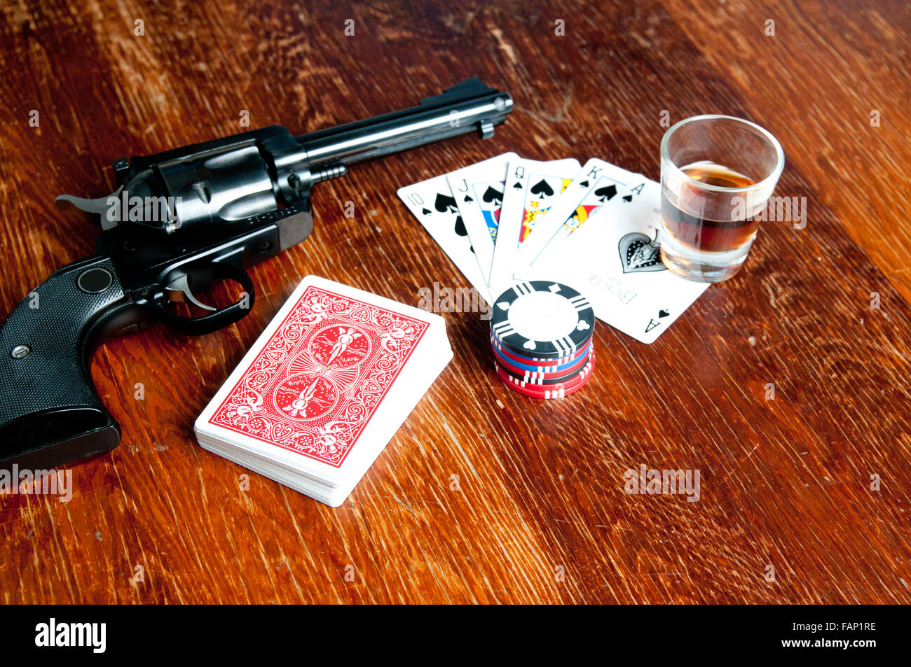 The old west poker game with six shooter, whiskey, cards and chips. A royal  flush is showing Stock Photo - Alamy