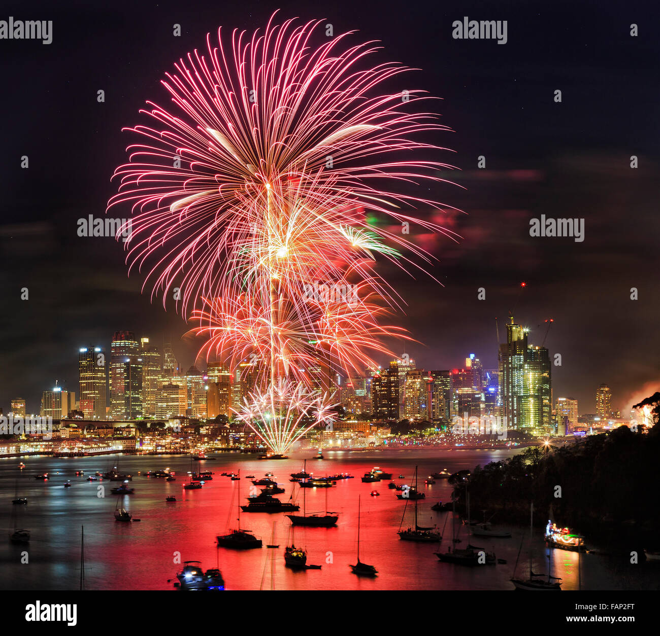 New year fireworks in Sydney from elevated lookout at Berrys bay over Sydney harbour with CBD skyscrapers under flash balls Stock Photo