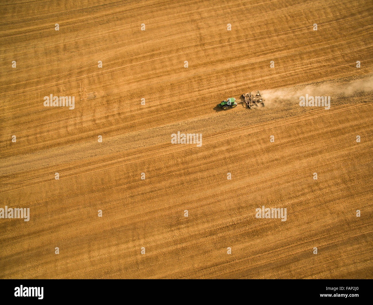 Aerial view of a tractor working a field after harvest Stock Photo - Alamy