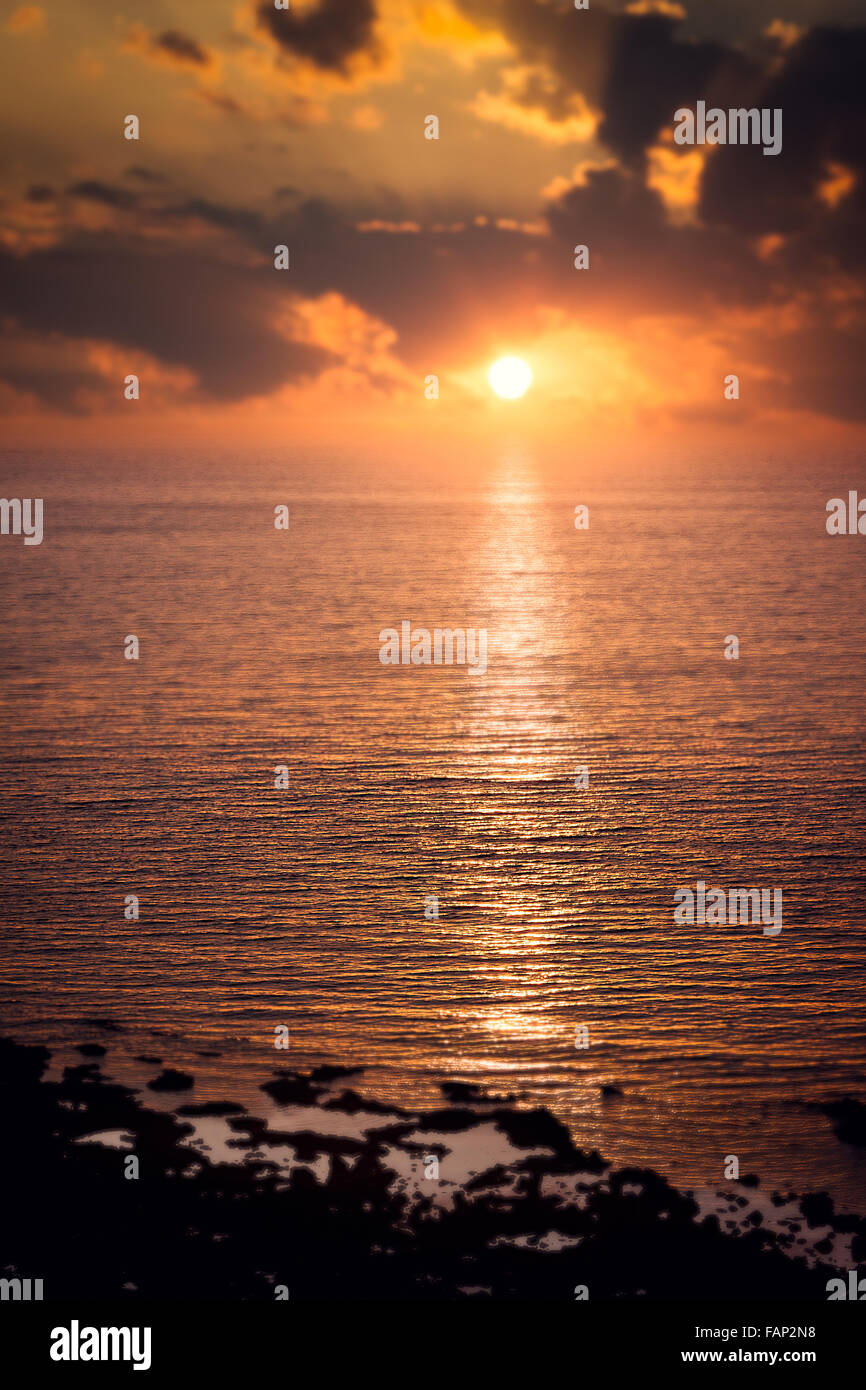 Cloudy sunset over a calm sea Stock Photo - Alamy