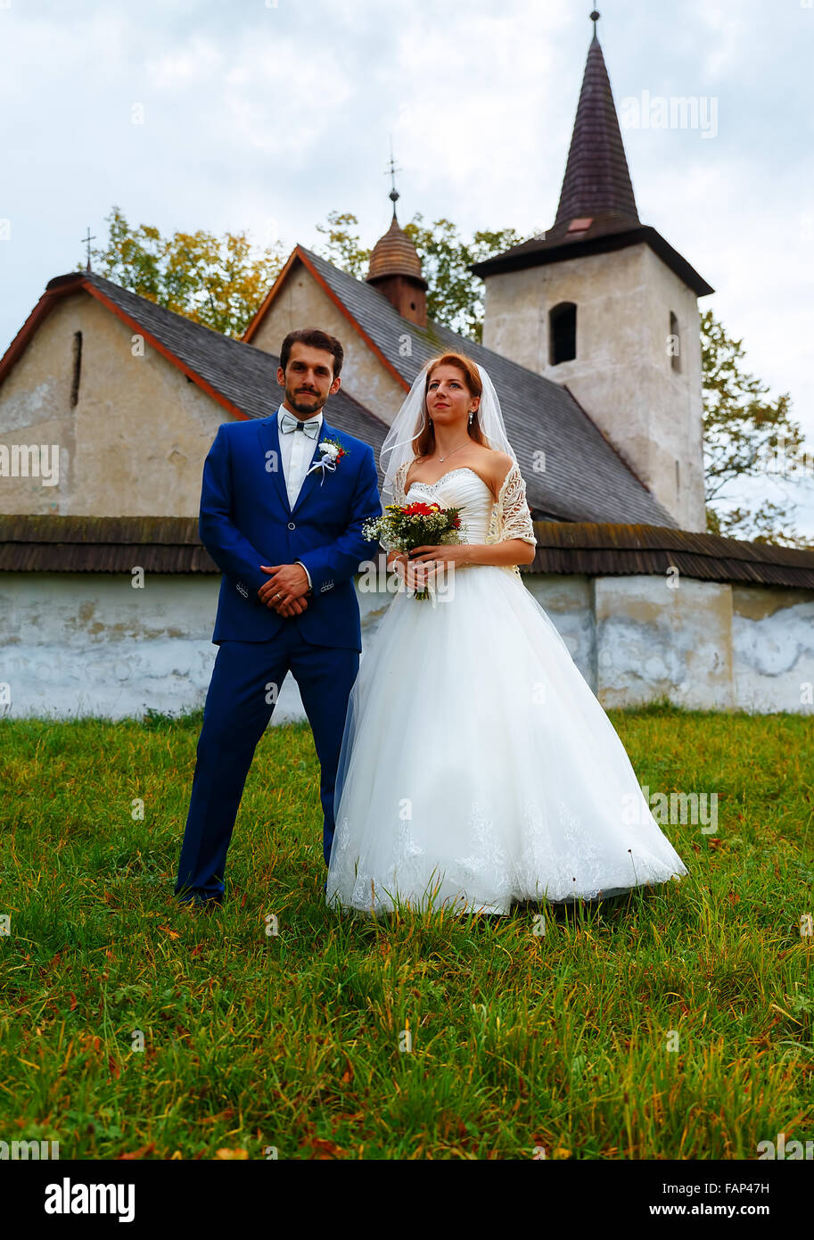 the bride and groom in front of a historical church Stock Photo - Alamy