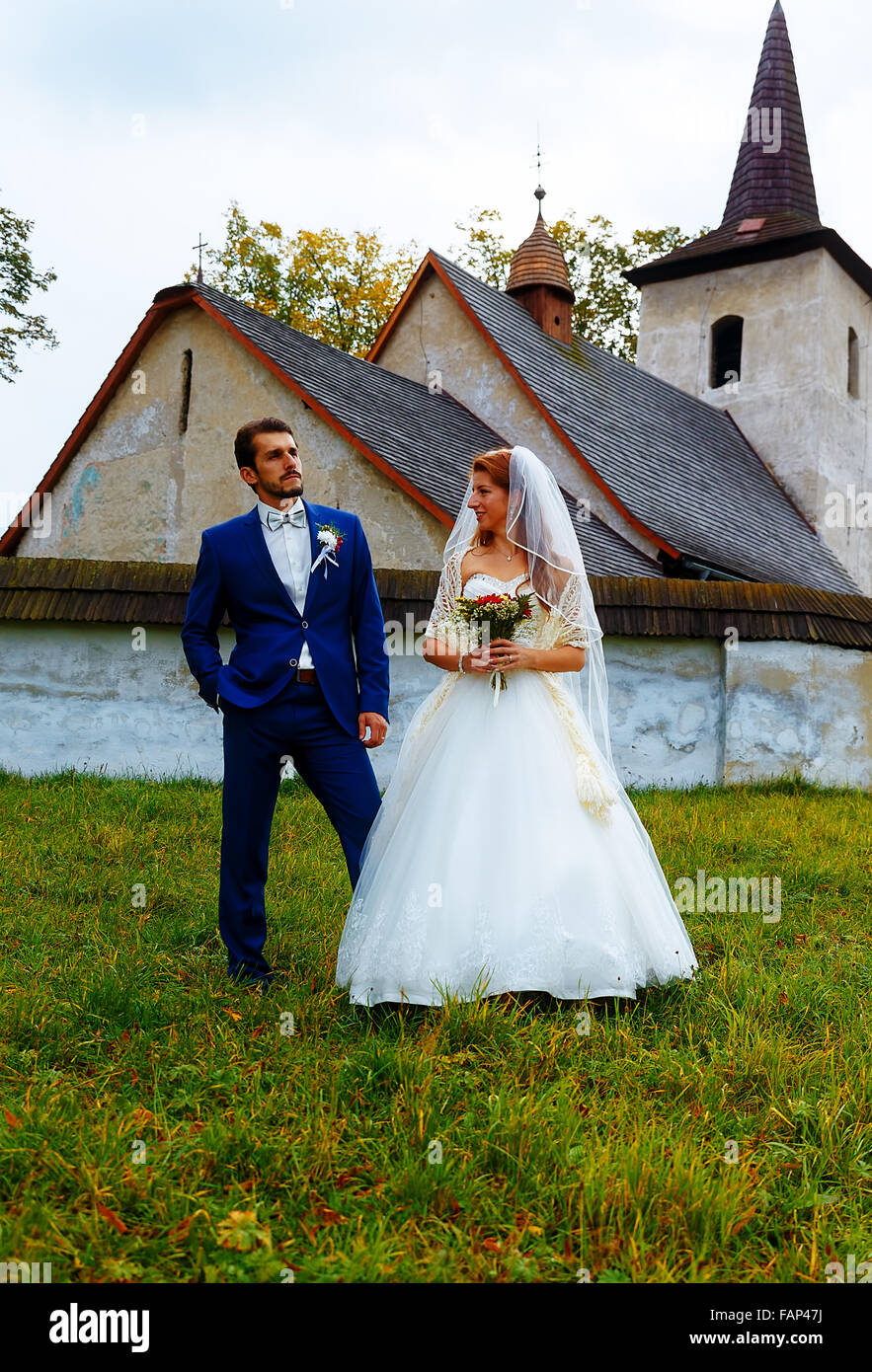 the bride and groom in front of a historical church Stock Photo - Alamy