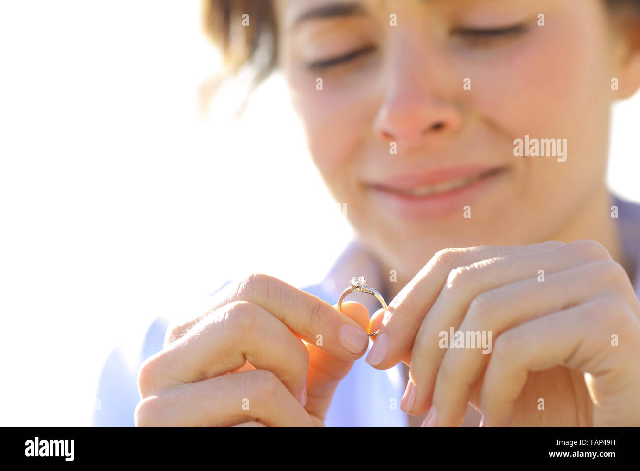 Sad girlfriend crying while is looking her engagement ring Stock Photo