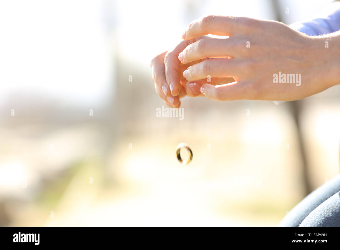 Sad wife hands dropping her wedding ring marriage problems concept Stock Photo