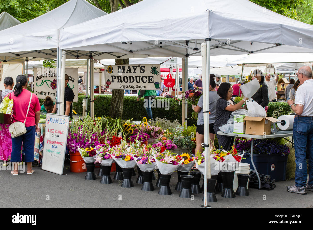 Flower vendor selling fresh bouquets to customers at the farmers market, Beaverton, Oregon, USA Stock Photo