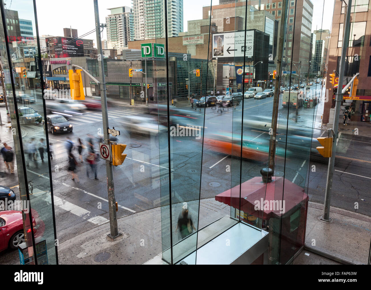 Busy urban intersection in the evening with busy traffic and pedestrians. Stock Photo