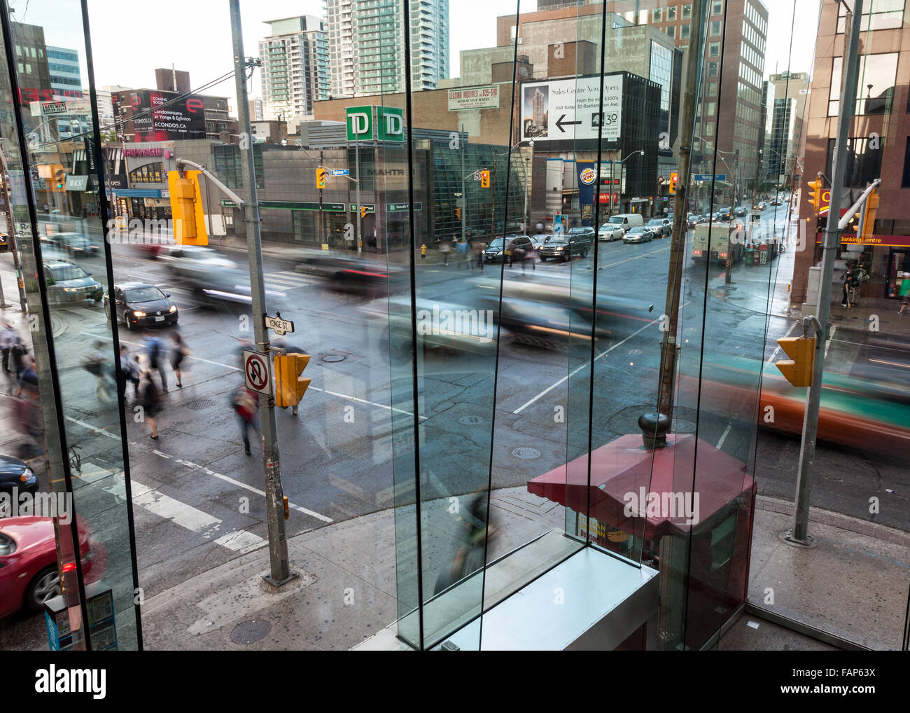 Busy urban intersection in the evening with busy traffic and pedestrians. Stock Photo