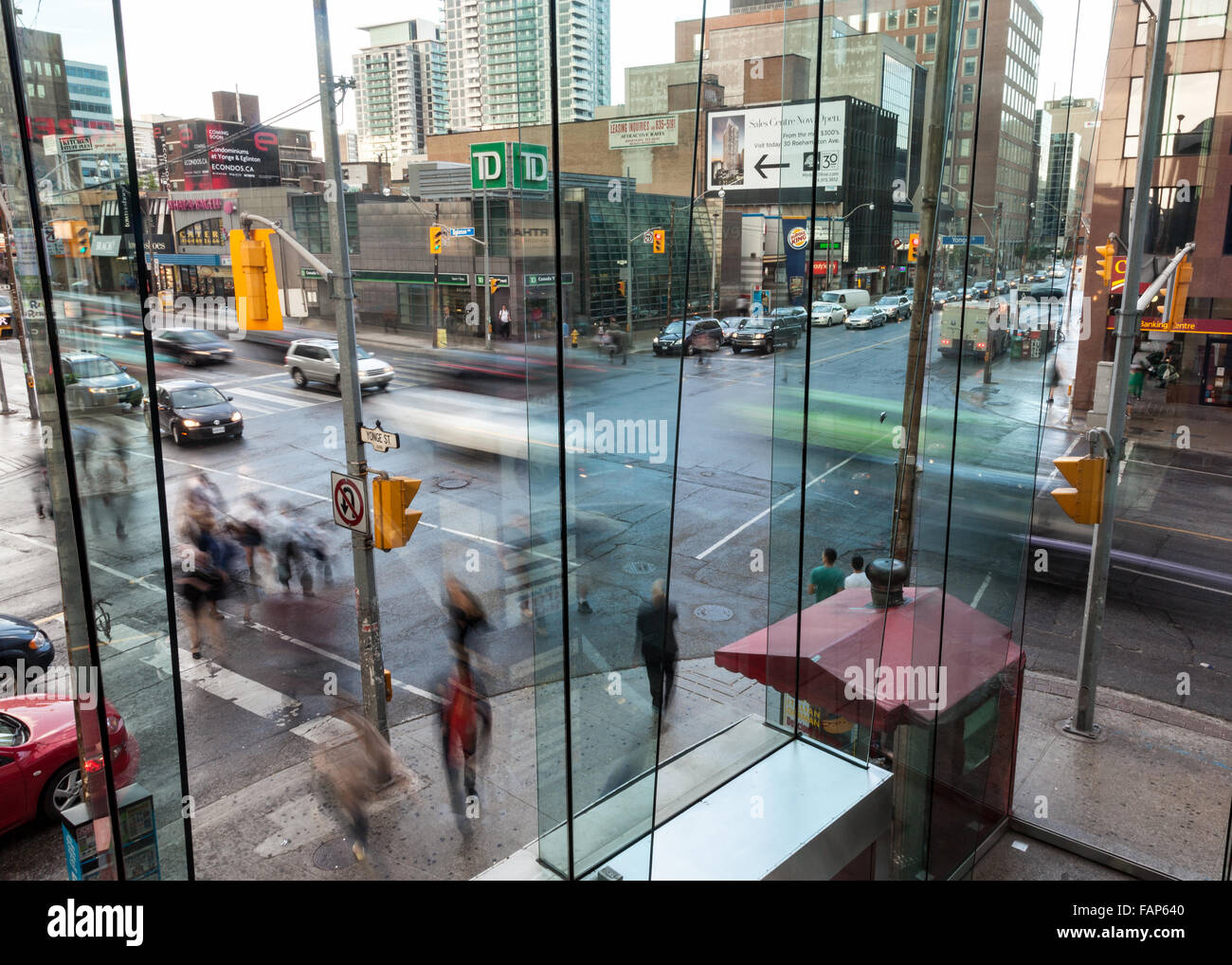 Busy urban intersection in the evening with busy traffic and pedestrians. Stock Photo