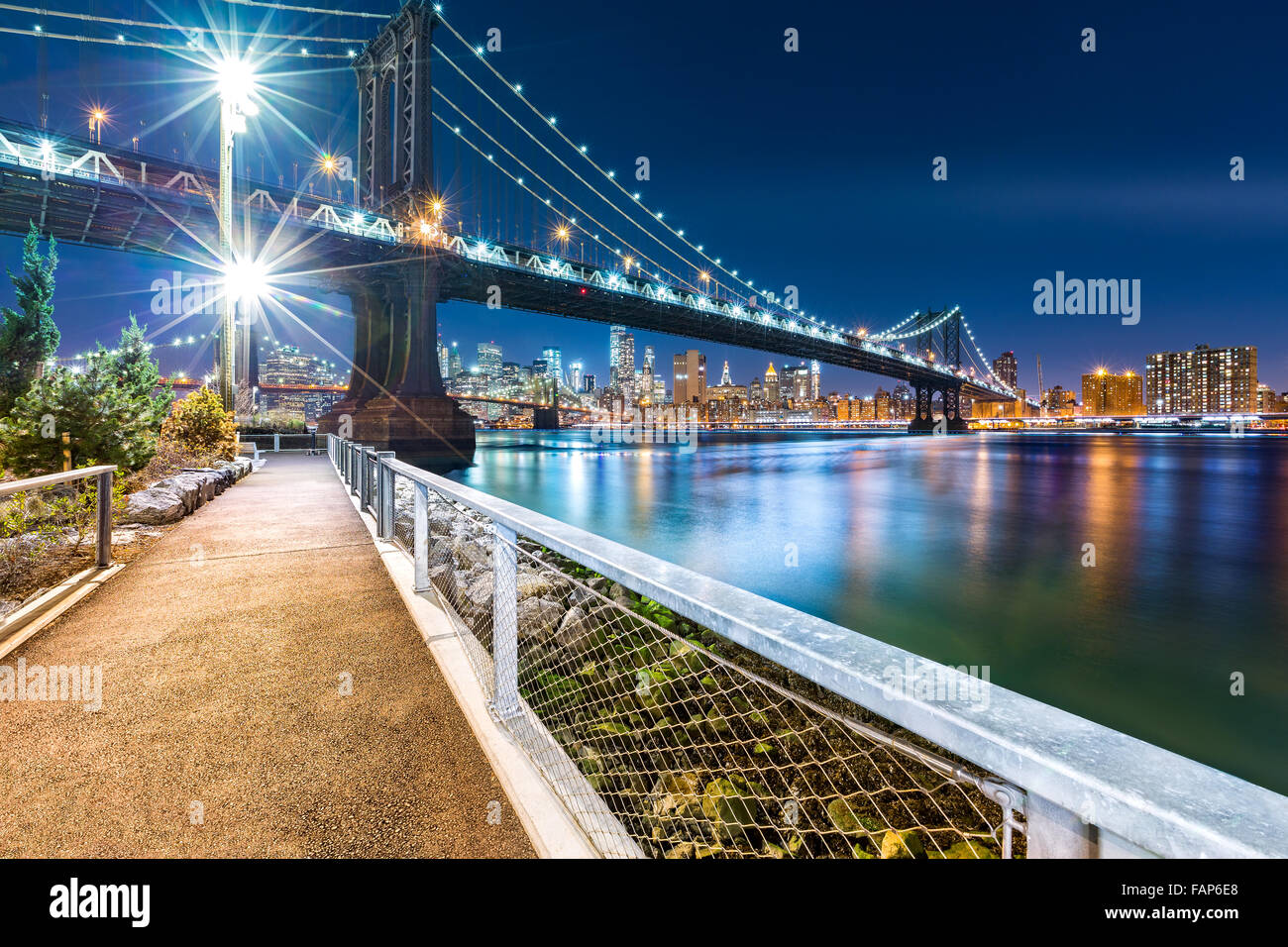 Manhattan Bridge by night, viewed from John Street Park with Brooklyn Bridge and Lower Manhattan skyline in the background. Stock Photo