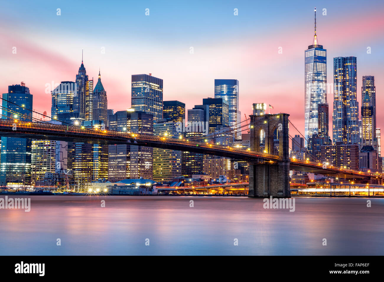 Brooklyn Bridge at and the Lower Manhattan skyline under a purple sunset Stock Photo