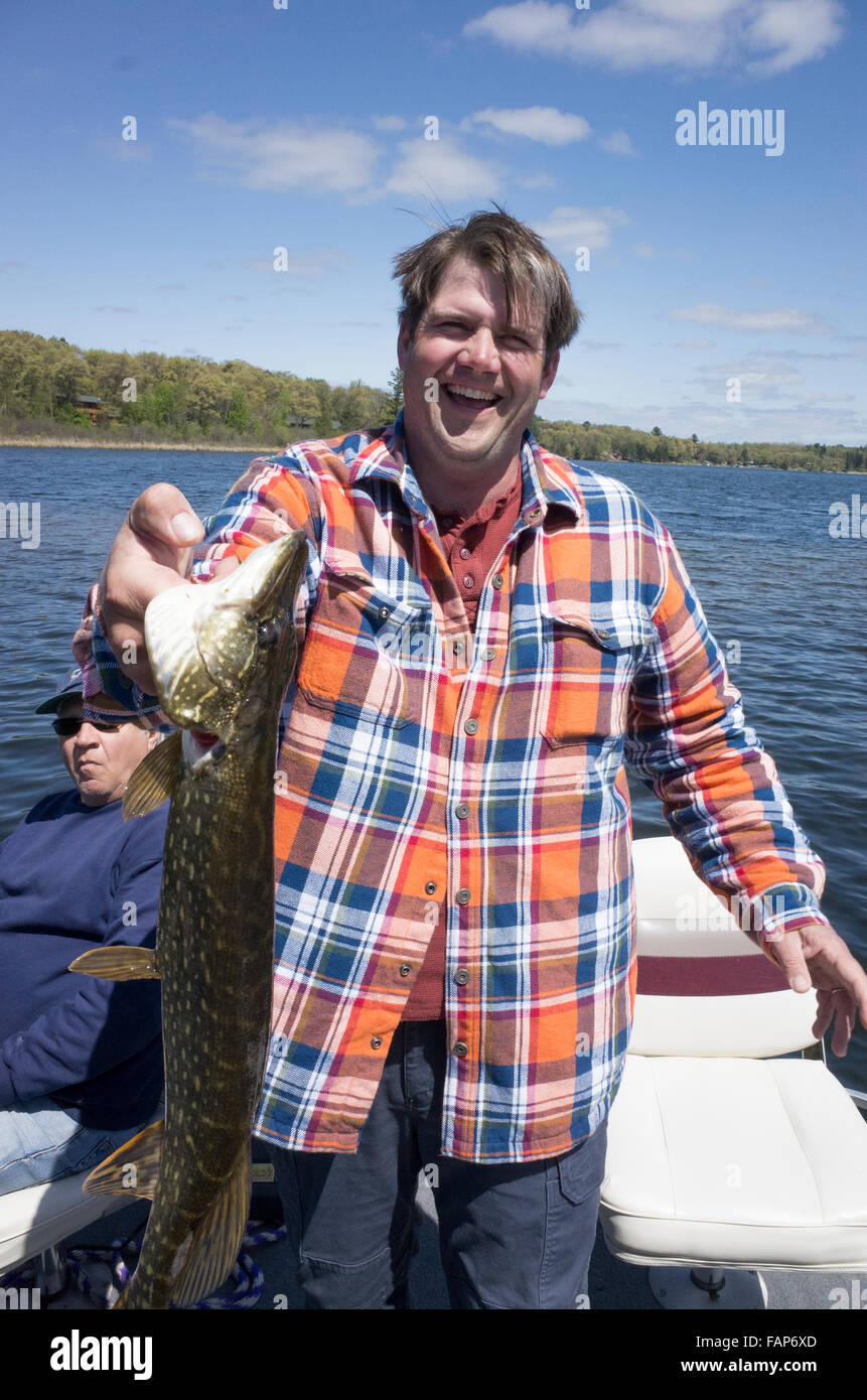 Fisherman screaming for joy after catching a Northern Pike fish in the Gull Lake chain of lakes. Nisswa Minnesota MN USA Stock Photo
