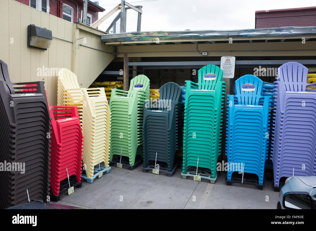 Array stacks of multicolored plastic Adirondack like summer lawn deck patio backyard chairs waiting. St Paul Minnesota MN USA Stock Photo