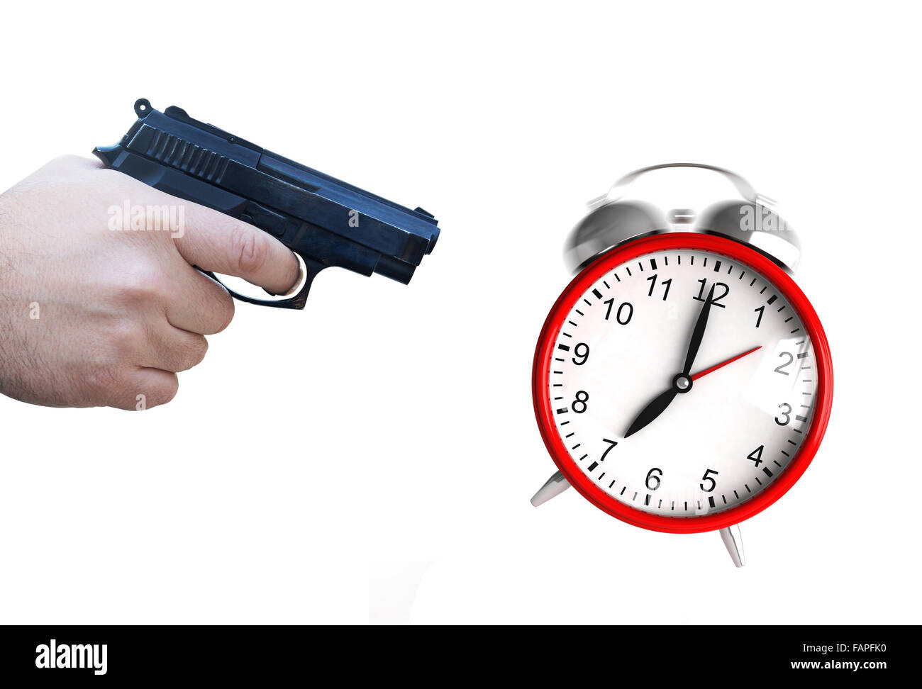 A hand with pistol ready to fire at an ringing clock Stock Photo