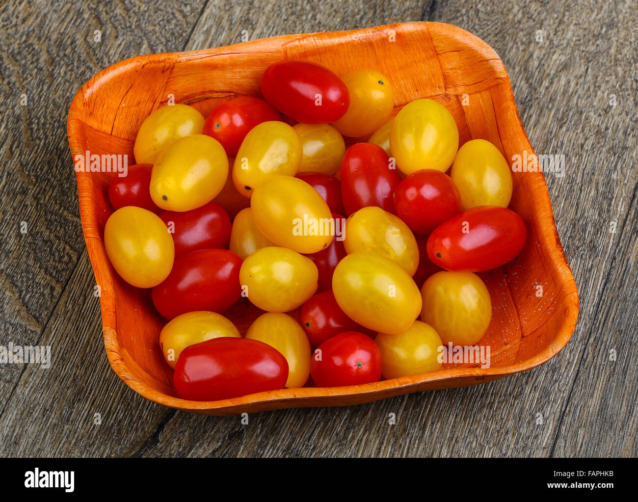 Yellow and red cherry tomatoes mix on the basket Stock Photo - Alamy