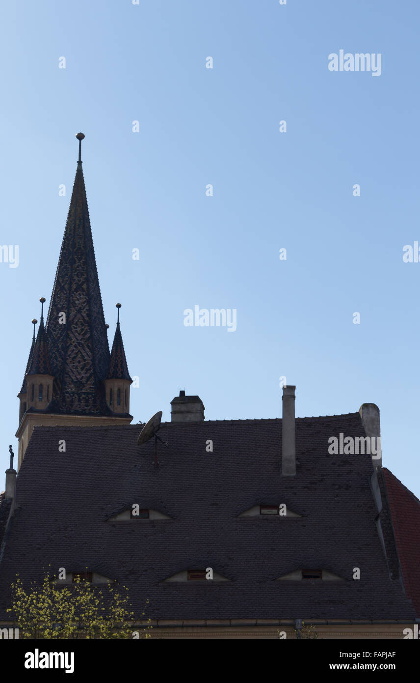 Church tower and window eyes on the roof of a medieval building Stock Photo
