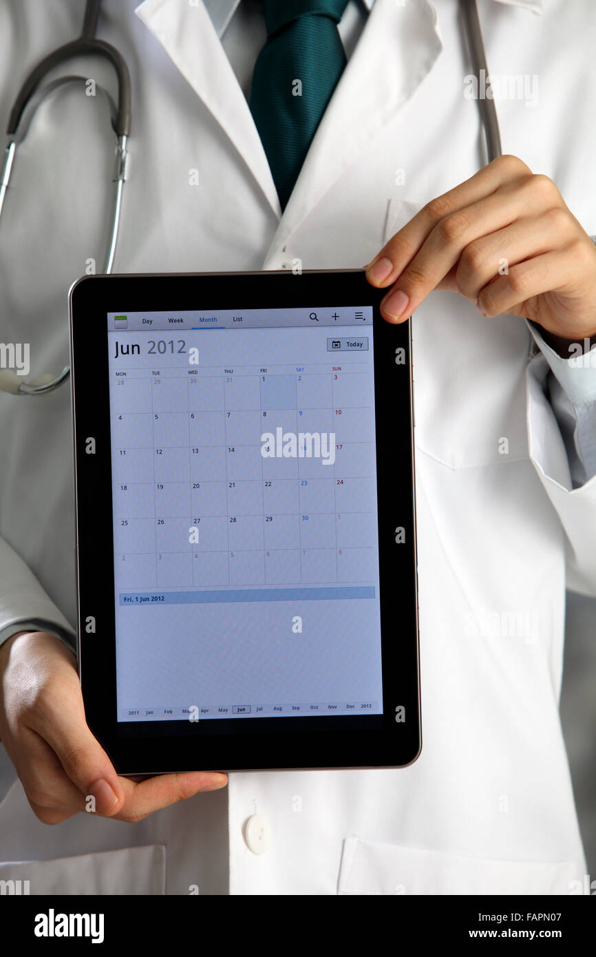 Doctor holding and showing digital tablet Stock Photo - Alamy
