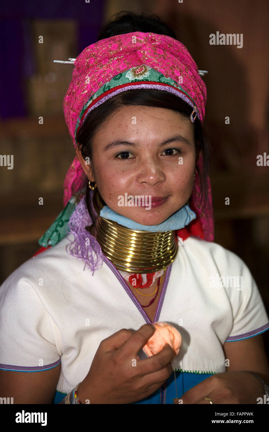 A woman from the Kayan tribe weaving in a workshop at Inle Lake in Myanmar (Burma). The woman wears brass coils on her neck. Stock Photo
