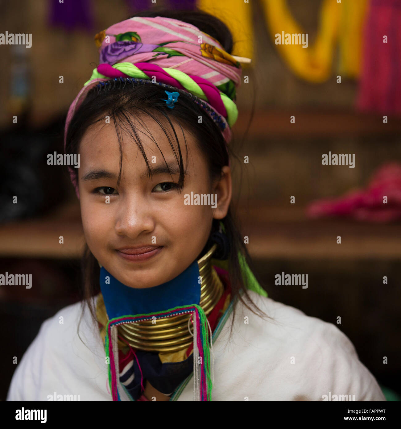 A woman from the Kayan tribe weaving in a workshop at Inle Lake in Myanmar (Burma). The woman wears brass coils on her neck. Stock Photo