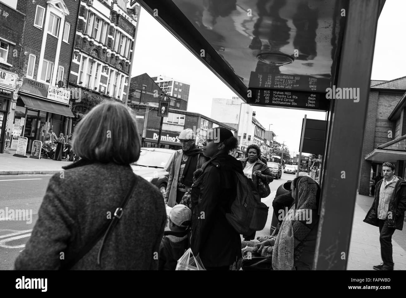 People waiting at bus stop in Leyton, East London Stock Photo