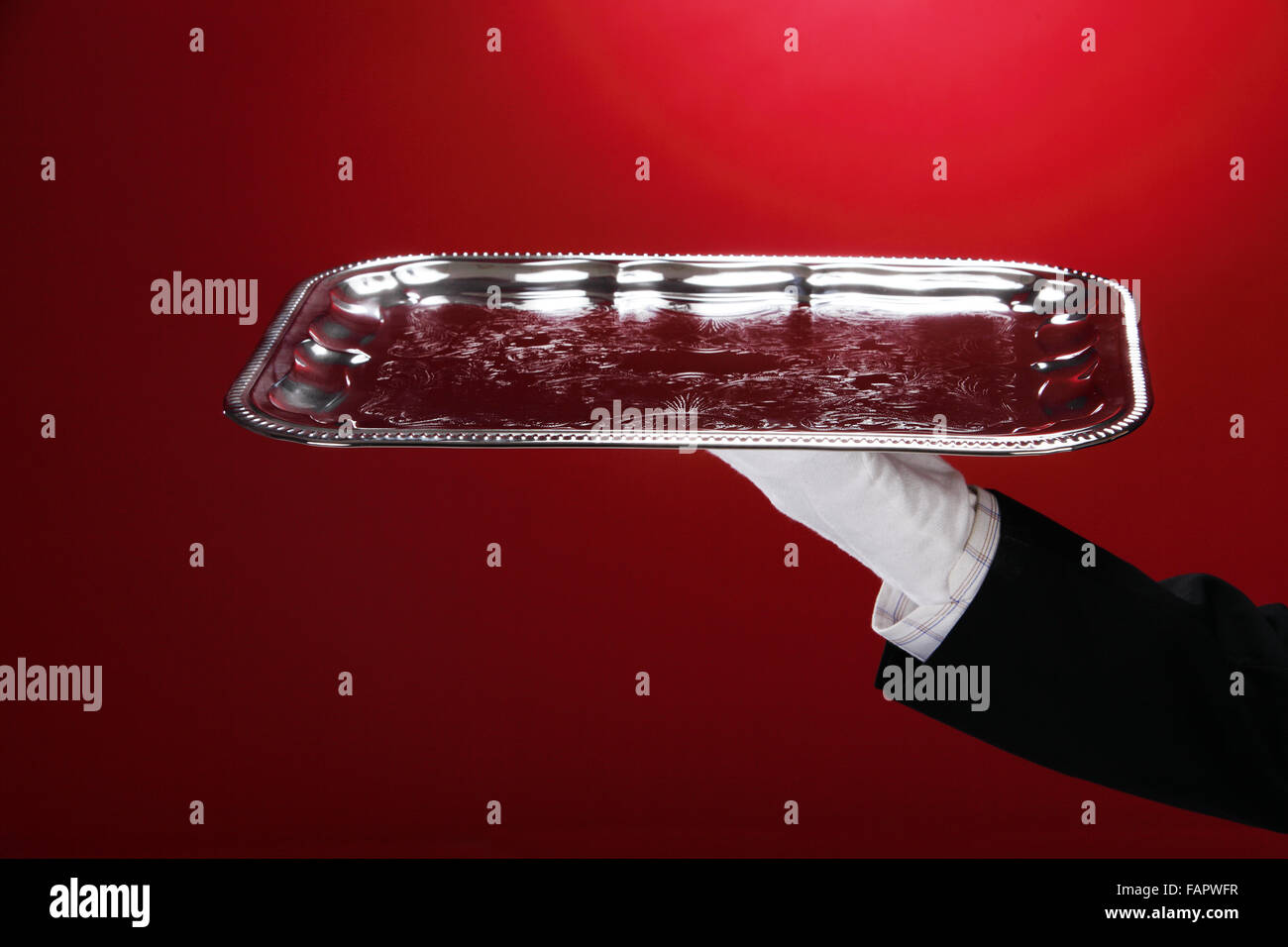 Butler carrying silver serving tray, close-up of hand Stock Photo