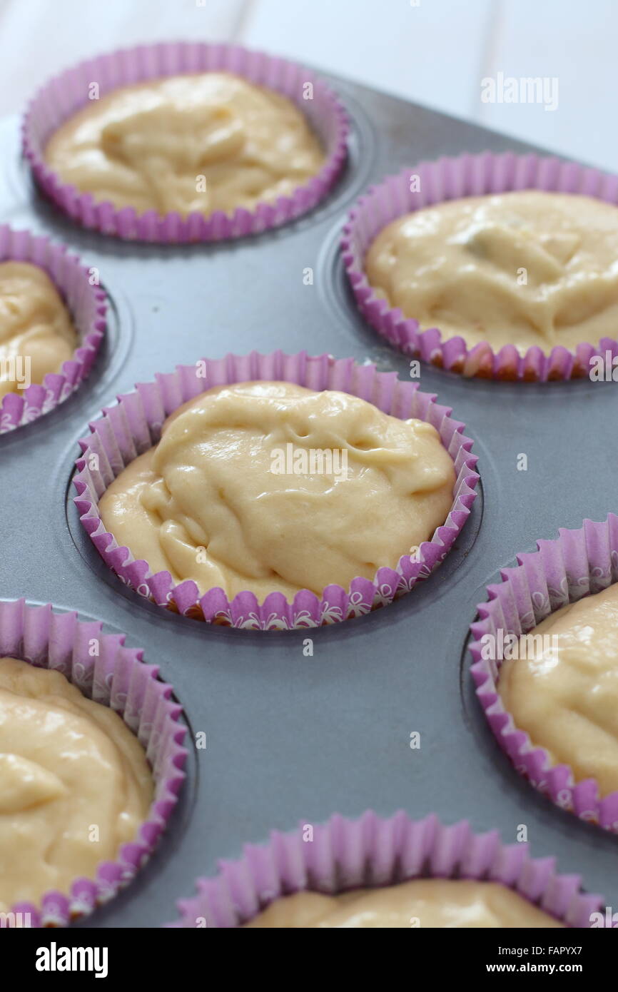 Scooping cupcake batter with a dough scoop into cupcake foil liners to bake  gingerbread cupcakes Stock Photo - Alamy