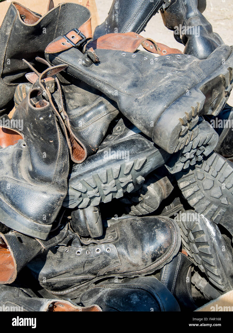 A heap of old leather worn military boots Stock Photo - Alamy
