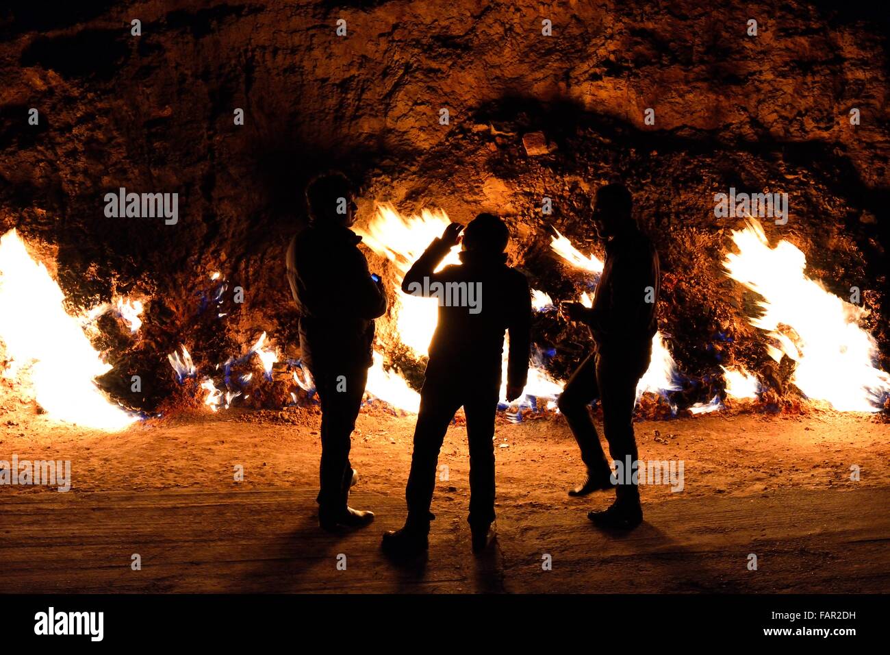 Men drinking at Yanar Dag. Gas naturally flows from rocks around 20km from Baku, capital of Azerbaijan Stock Photo