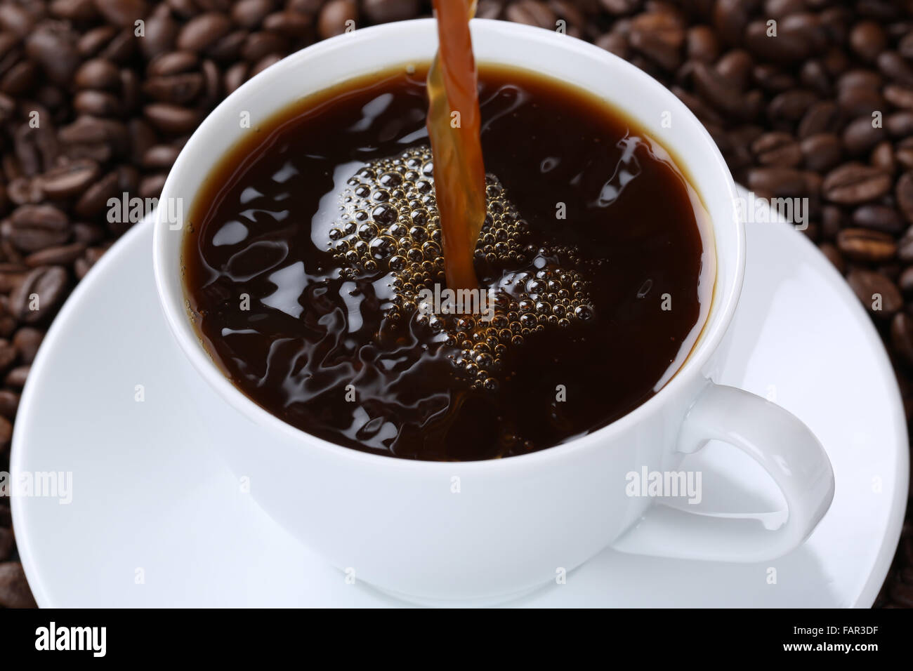 Hot coffee drink pouring in cup with beans Stock Photo