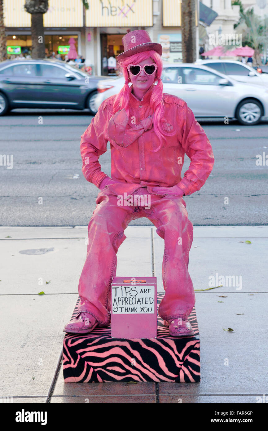 Street artist dressed in pink sitting on an invisible chair, Las Vegas Boulevard, Las Vegas, Nevada. Stock Photo