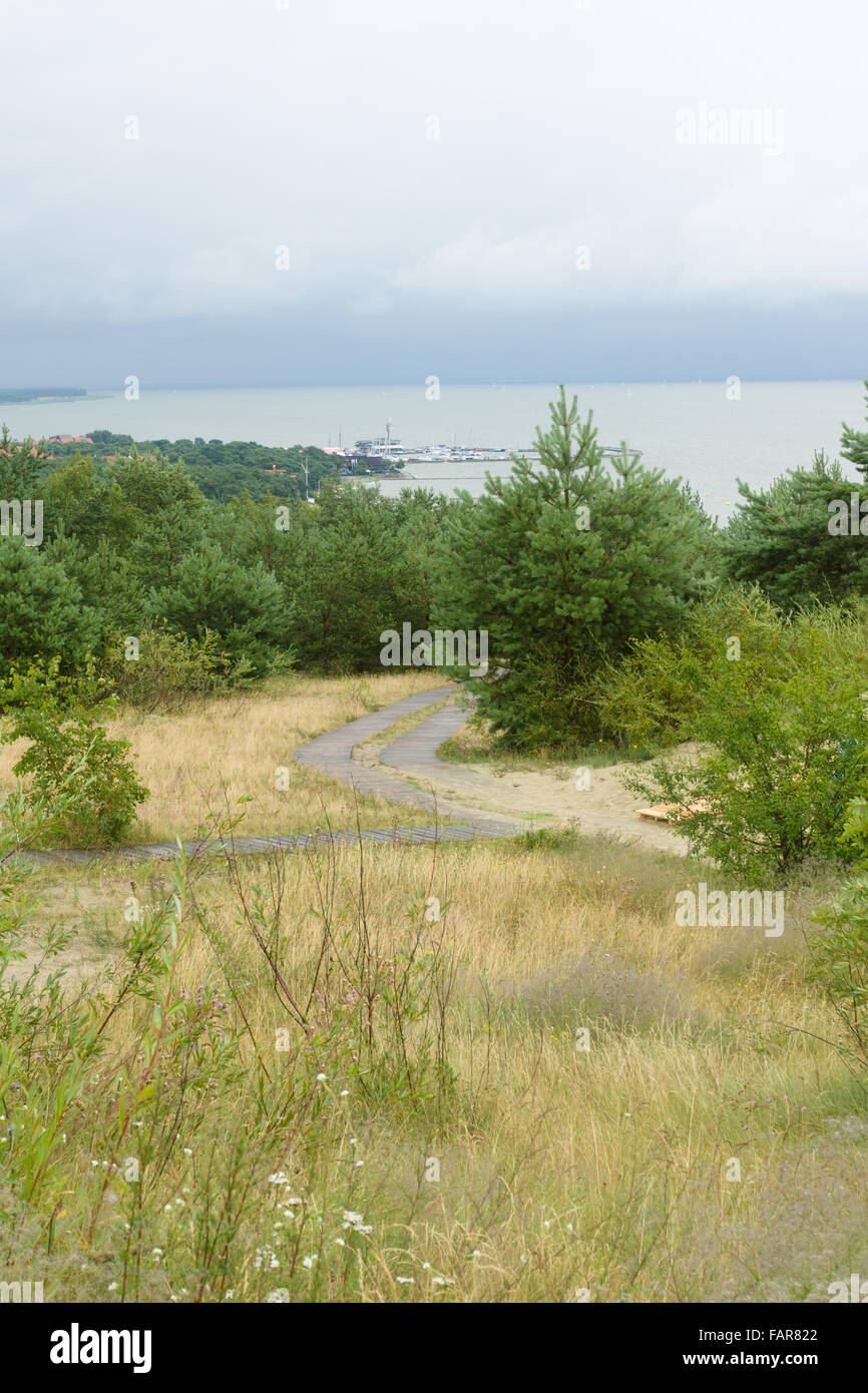 the sandy road conducting with the hill to the far city Stock Photo