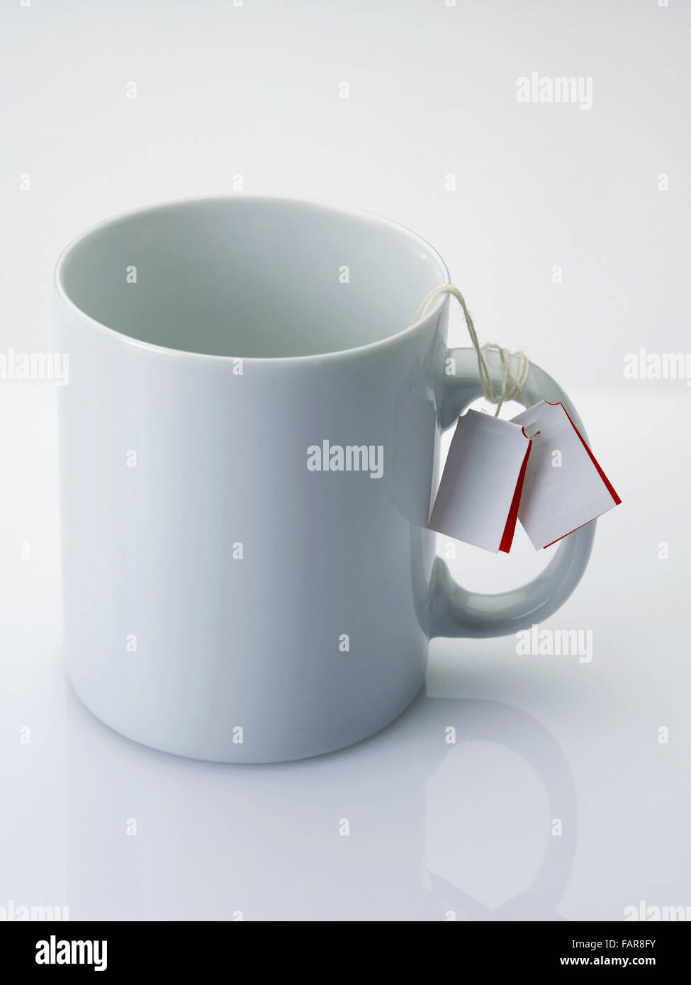 mug with tea bag on the plain background Stock Photo - Alamy