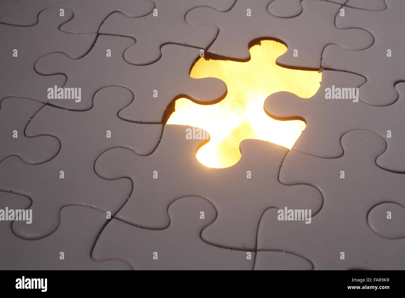 Jigsaw puzzle placed over light. Stock Photo
